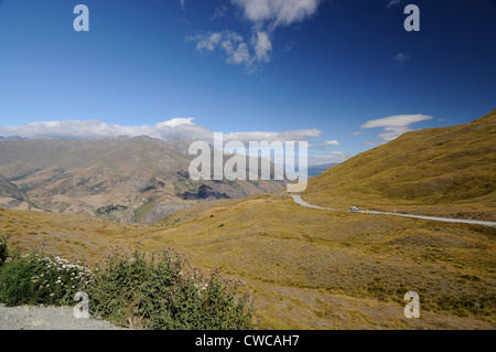 Die Crown Range Road windet sich in die Crown Range Mountains zwischen Arrowtown und Wanaka in Otago, Neuseeland. Stockfoto