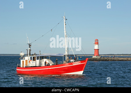 Angelboot/Fischerboot vorbei an den Leuchttürmen an der Mündung des Flusses Warnow, Warnemünde, Mecklenburg-West Pomerania, Deutschland Stockfoto