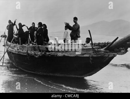 Vietnamesische Flüchtlinge kommen in Da Nang, Südvietnam. Stehend auf einem Fischerboot, applaudieren sie sicheren Hafen erreichen Stockfoto