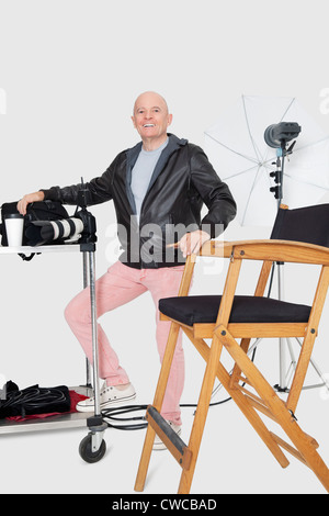 In voller Länge Portrait von glücklich senior Fotograf mit Ausrüstungen im studio Stockfoto