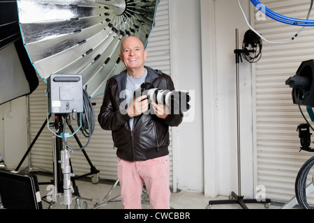 Porträt von glücklich senior Fotograf mit Kamera im studio Stockfoto