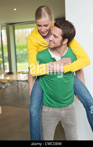Frau Reiten Huckepack auf ihren Freund Stockfoto