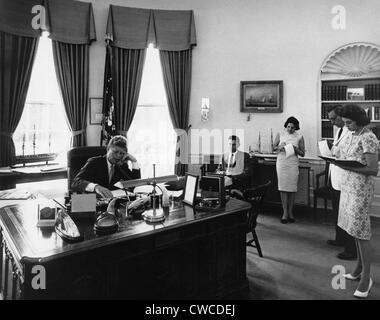 Präsident John Kennedy spricht AMVETS Convention in New York City per Telefon. Mitarbeiter und Journalisten machen Sie sich Notizen während er spricht Stockfoto