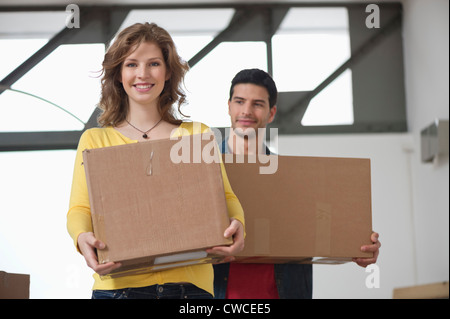 Paar mit Kartons und lächelnd Stockfoto