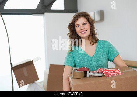 Frau mit Karton und lächelnd Stockfoto