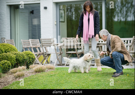 Paar mit ihren Haustieren in einem Garten spielen Stockfoto