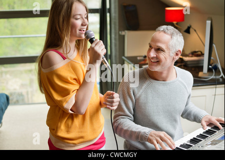 Man spielt ein Klavier mit seiner Tochter singen Stockfoto