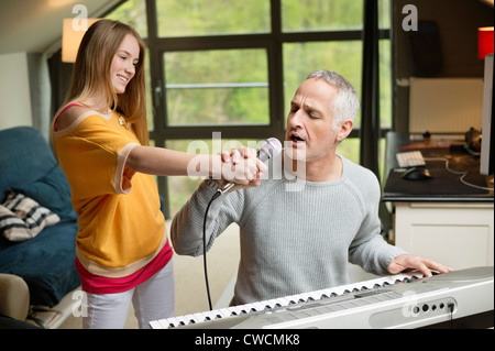 Man singt und spielt ein Klavier mit seiner Tochter zu Hause Stockfoto