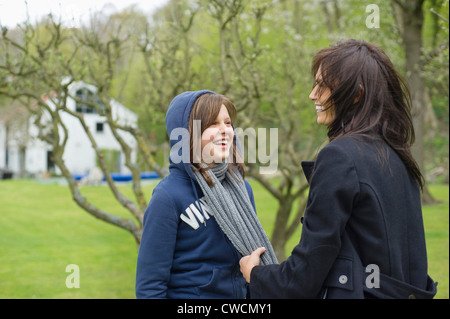 Frau mit ihrer Tochter in einem Obstgarten Spaß Stockfoto