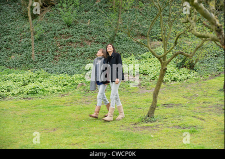 Frau mit ihrer Tochter zu Fuß in einem Obstgarten Stockfoto