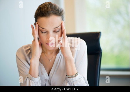 Eine Geschäftsfrau, leiden unter Kopfschmerzen in einem Büro in Nahaufnahme Stockfoto