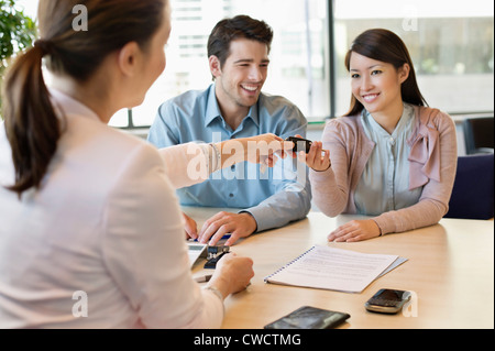 Schlüsselübergabe von Geschäftsmann paar Stockfoto
