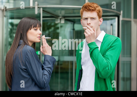 Geschäftsleute, die vor einem Bürogebäude Rauchen Stockfoto