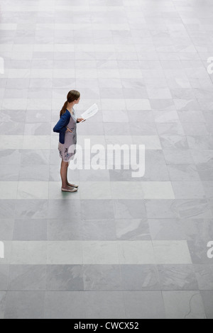 Geschäftsfrau hält Dokumente und stehen in einem Büro-lobby Stockfoto