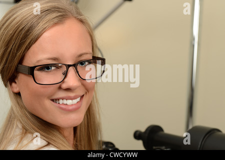 Schöne weibliche Optiker lächelnd im Untersuchungsraum Stockfoto