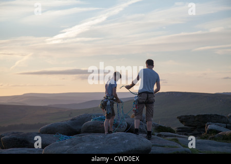 Zwei Bergsteiger auf Stanage Edge, Derbyshire, wickeln ihre Seile am Ende des Tages. Stockfoto