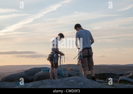 Zwei Bergsteiger auf Stanage Edge, Derbyshire, wickeln ihre Seile am Ende des Tages. Stockfoto