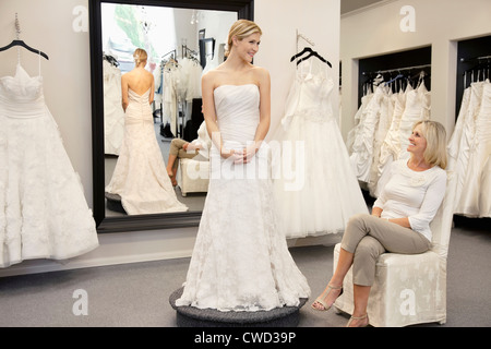 Glückliche Mutter Tochter betrachten gekleidet in Hochzeitskleid Braut Boutique Stockfoto