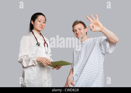 Porträt des Patienten gestikulieren Okay mit Arzt hält eine Zwischenablage Stockfoto