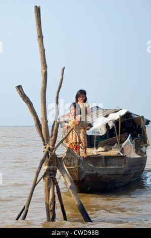 Vertikale Porträt von zwei jungen Mädchen stehen auf einem Boot in Kompong Khleang, das schwimmende Dorf am See Tonle Sap in Kambodscha Stockfoto