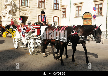 Touristen genießen Sightseeing aus traditionellen Pferdekutsche im Hofburg Palast in Wien, Österreich Stockfoto