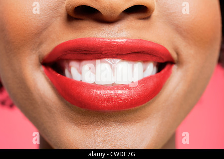 Nahaufnahme Detail einer afroamerikanischen Frau lächelnd über farbigen Hintergrund Stockfoto