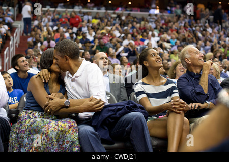 Präsident Barack Obama küsst First Lady Michelle Obama für die Kiss Cam während der Teilnahme an der US-Männer-Olympischen Basketball-Team-Spiel gegen Brasilien im Verizon Center 16. Juli 2012 in Washington, D.C.-Vize-Präsident Joe Biden und Malia Obama nachschlagen auf dem Großbildschirm. Stockfoto
