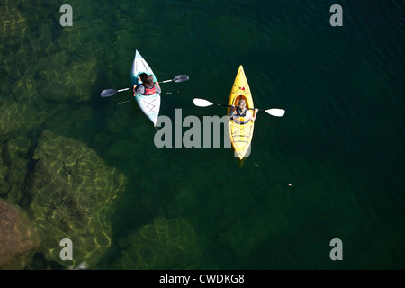 Ein junge Erwachsene paar Kajak an einem sonnigen Tag auf einem See in Idaho. Stockfoto