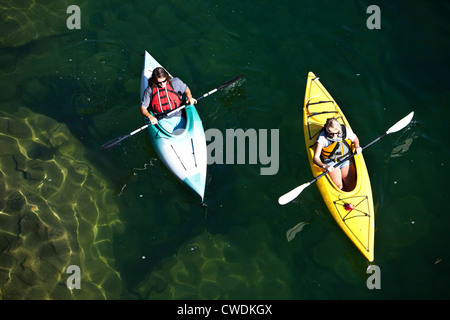 Ein junge Erwachsene paar Kajak an einem sonnigen Tag auf einem See in Idaho. Stockfoto