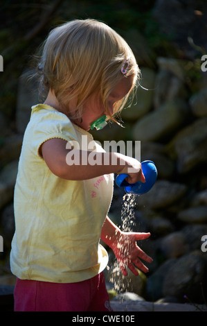 Kind blondes Mädchen Baby mit Sand im Sandkasten spielen Stockfoto