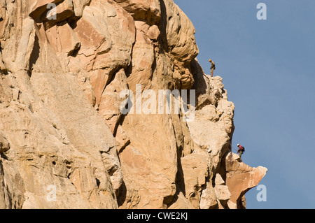 Zwei Männer Klettern eine Sandstein-Bug in San Rafael Swell, Green River, Utah. Stockfoto