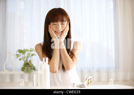 Japanerin mit Kopf lächelnd In der Hand Stockfoto