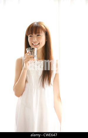 Fröhliche japanische Frau mit Trinkglas Stockfoto