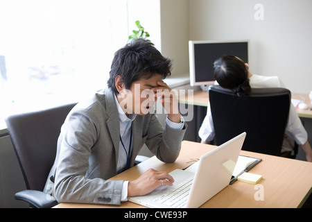 Geschäftsmann erschöpft und bei geschlossenen Augen Stockfoto