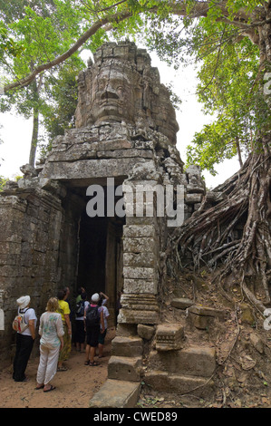 Vertikale Ansicht eines Steins konfrontiert Gopura Eingänge zum Ta Prohm oder der Tomb Raider-Tempel mit Touristen zu Fuß durch. Stockfoto