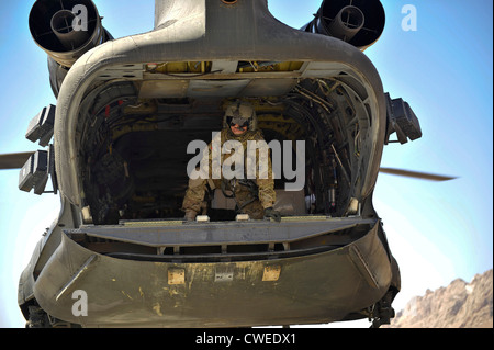 Ein Besatzungsmitglied an Bord ein CH-47 Chinook-Hubschrauber leitet Informationen an den Piloten, wie das Flugzeug nähert sich eine entfernte Landezone Lieferungen 10. März 2012 in Shah Freude District, Provinz Zabul in Afghanistan abgeben. Hubschrauber bieten Koalition Spezialkräfte eine effiziente und zuverlässige Mittel für den Transport von Personal und Fracht im ländlichen Afghanistan. Stockfoto