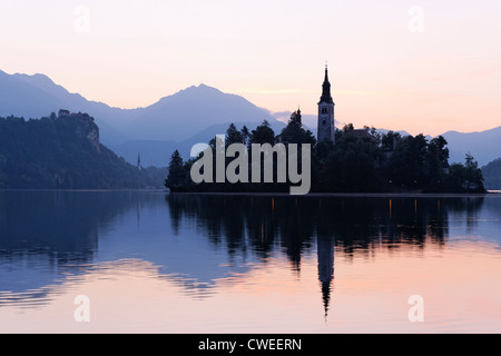 Bleder See und die Kirche Mariä Himmelfahrt auf der Insel Blejski Otok mit Burg von Bled hinter. Bled, Gorenjska, Slowenien. Stockfoto