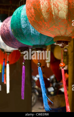 Vertikale Nahaufnahme von traditionellen Seidenlaternen hängen in der Sonne in Vietnam. Stockfoto