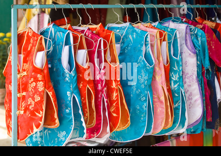 Horizontal von vielen bunten traditionellen Áo Bà Ba hautnah, Seide Schlafanzug, bereit für den Verkauf in einem Geschäft in Vietnam aufgehängt. Stockfoto