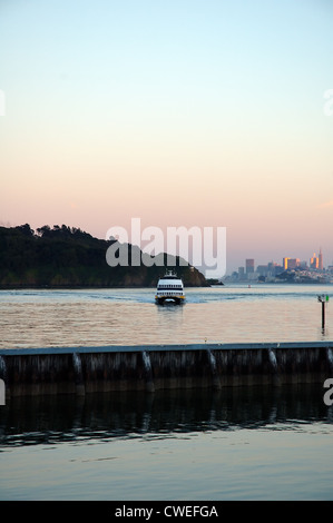 Eine Fähre auf der San Francisco Bay, die sich dem Yachthafen von Tiburon im Marin County, Kalifornien, USA nähert. Angel Island liegt im Hintergrund. Stockfoto