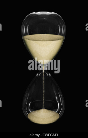 Eine Sanduhr zeigt den Sand der Zeit vergeht auf schwarzem Hintergrund isoliert Stockfoto