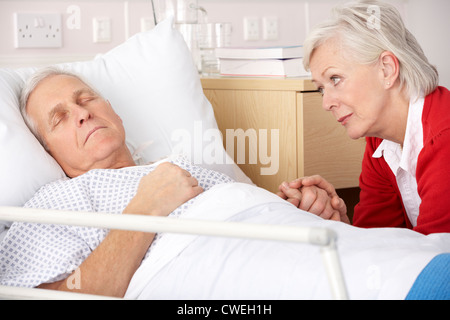 Ältere Frau besuchen Mann im Krankenhaus Stockfoto