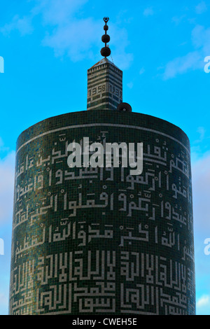 Runde Minarett Turm mit arabischer Schrift eingraviert ist, es gegen den blauen Himmel in Moulay Idriss silhouetted, Marokko. Stockfoto