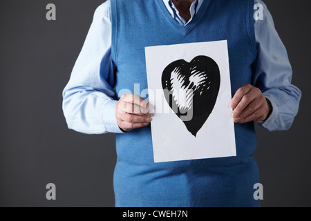 Senior woman holding Tusche-Zeichnung des Herzens