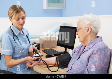 UK-Krankenschwester, die die ältere Frau Blutdruckmessung Stockfoto