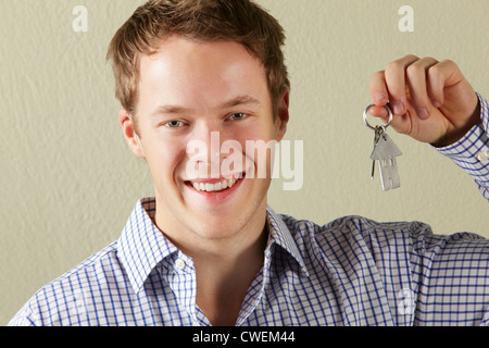 Studioaufnahme der junge Mann, der Schlüssel zum ersten zu Hause hält Stockfoto