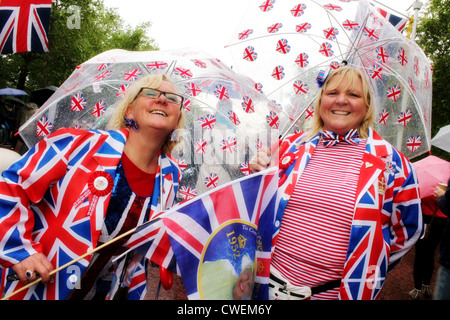 Feiern im Regen an der Königin Diamond Jubilee London 2012. Zwei Frauen in der Union Jack Kleidung gekleidet Stockfoto