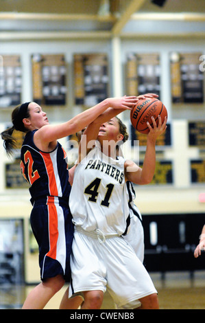 Basketball Spieler versucht Kugel an Mädchen High School Spiel zu blockieren. USA. Stockfoto