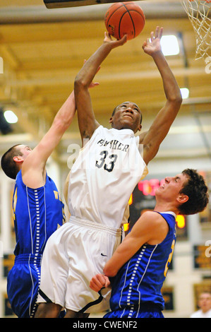 Basketball Spieler schießen zwischen zwei Verteidiger bei einem High School Spiel. USA. Stockfoto