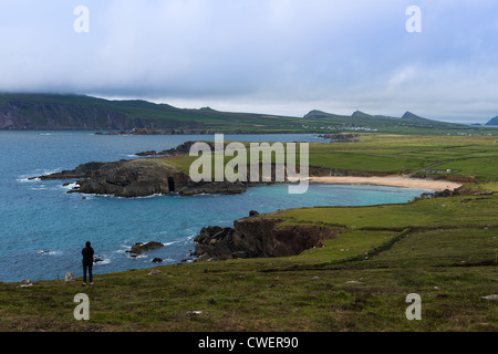 Eine einsame Gestalt einen Blick über die Bucht in der Nähe von Slea Head, Halbinsel Dingle, County Kerry, Irland. Stockfoto